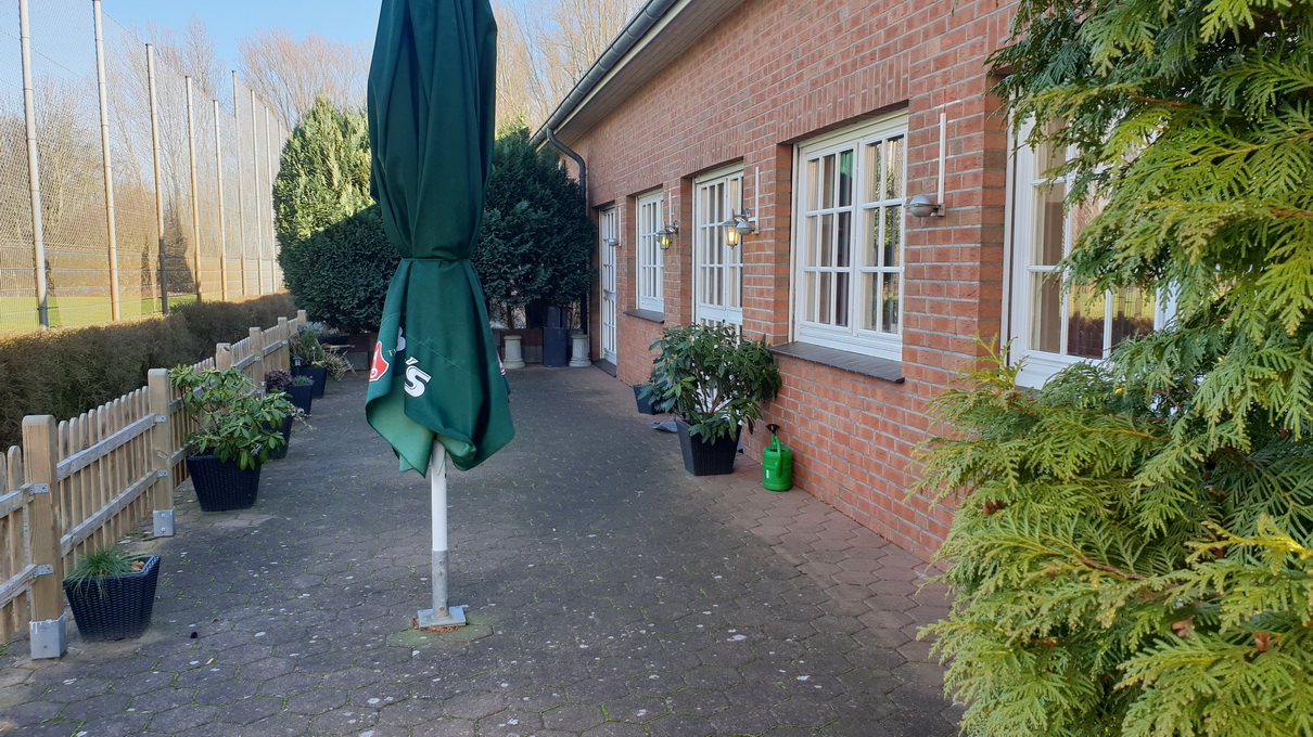 Biergarten-Terrasse am TURA-Vereinszentrum mit Sitzplätzen und Sonnenschirmen